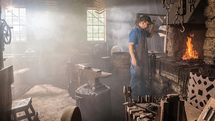 A John Deere blacksmith working at the forge