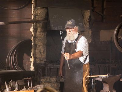 A John Deere blacksmith performing a demonstration at the Historic Site