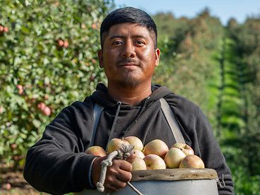 A farmer holding a basket of fresh produce