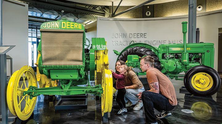 A family enjoys looking at vintage tractors at the Tractor and Engine Museum
