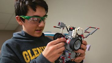 Student standing with their LEGO creation.