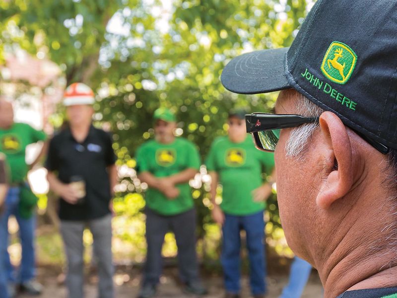 Closeup view of a Habitat for Humanity volunteer facing a group of more volunteers.
