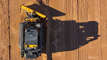 Aerial view of John Deere loader moving dirt on a worksite.